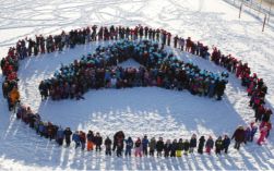 Children in a field forming the letter A