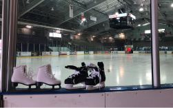 Image of skates leaning against glass of skating arena