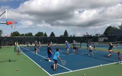 Chilren playing tennis in an outdoor tennis court