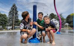 kids enjoying an outdoor water splash pad in summer