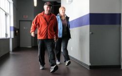 A man and woman walking on an indoor track